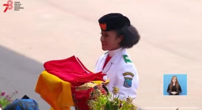 
Lilly Wenda,Saat Membawa Baki Baki Pada Pengibaran Bendera Merah Putih di Istana Negara.Foto: Capture YouTube Sekretariat Presiden