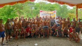 Dinas Pariwisata Kebudayaan Pemuda dan Olahraga Kabupaten Mimika berfoto bersama para penari perang-perangan.