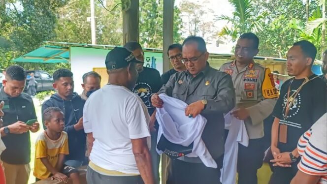Deputi Bidang Dukungan Teknis Bawaslu Republik Indonesia (RI), Dr. La Bayoni saat memberikan baju untuk dipakai kepada salah satu masyarakat Kampung Walani, Distrik Kwamki Narama, Kabupaten Mimika. (Foto: Edwin Rumanasen)
