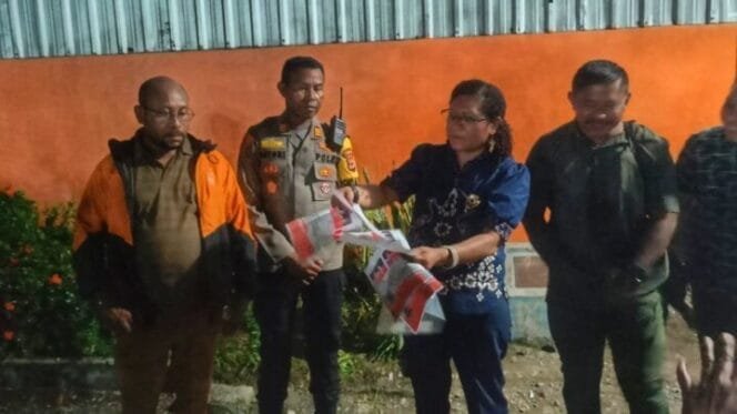 
Ketua KPU Nabire, Sarlota Wartanoy saat menunjukan surat suara rusak di depan Gudang logistik. (Foto: Edwin Rumanasen)
