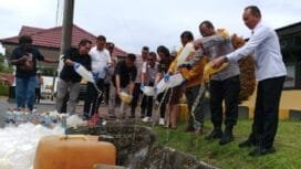 Kapolres Mimika bersama tamu undangan saat memusnahkan miras lokal jenis sopi dengan cara dituangkan ke dalam parit. (Foto: TIM Sasagupapua.com)