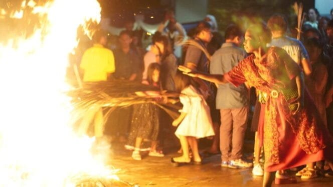 
Seorang umat saat melempar daun palem kering ke api. (Foto: Kristin Rejang/Sasagupapua.com)
