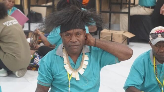 
Seorang pemuda menunjukan Mahkota dan Kawitok (di leher). (Foto: Edwin Rumanasen/Sasagupapua)