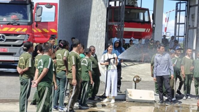 
Seorang guru pendamping saat memperagakan menggunakan alat pemadam kebakaran di UPPKB Bandara Douw Aturure.
