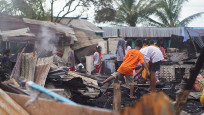 
Tampak anak-anak bermain di sekitar puing-puing rumah yang terbakar di Smoker Bawah, Kabupaten Nabire, Papua Tengah, Kamis (28/8/2025). (Foto: Edwin Rumanasen/Sasagupapua)