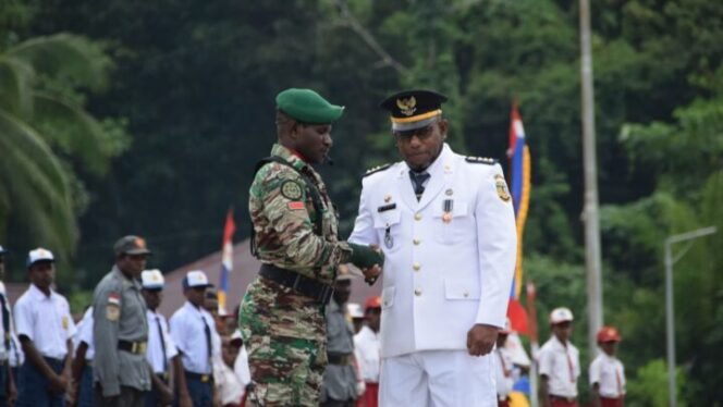 
Kepala Distrik Mimika Barat Jauh, Ever Kukuareyau saat bersalaman dengan pemimpin upacara. (Foto: Istimewa) 