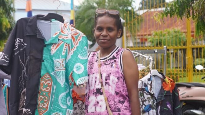 
Roberta Muyapa saat memegang salah satu baju jualannya dengan motif dari suku Mee. (Foto: sasagupapua)