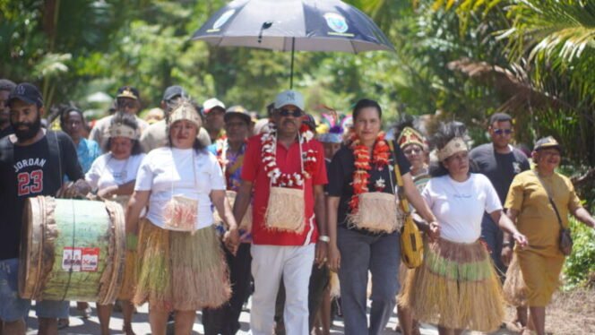 
Mesak Magai didampingi istri dan rombongan ketika tiba di Kampung Akudiomi,  Jumat (12/9/2025). Foto: sasagupapua.com