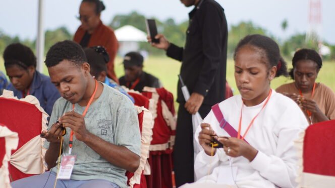 
Dua anak muda Papua sedang serius merajut noken saat lomba meriahkan Hari Sumpah Pemuda yang diselenggarakan oleh Dinas Kepemudaan, Olahraga, Pariwisata dan Ekonomi Kreatif, Selasa (28/10/2025). Foto: Kristin Rejang/Sasagupapua.com