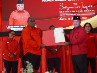 Gubernur Meki Nawipa saat menyerahkan sertifikat tanah kepada Ketua DPD PDI- Perjuangan Papua Tengah, Yuni Wonda. Rabu (5/11/2025). Foto: Edwin Rumanasen/Sasagupapua.com. 