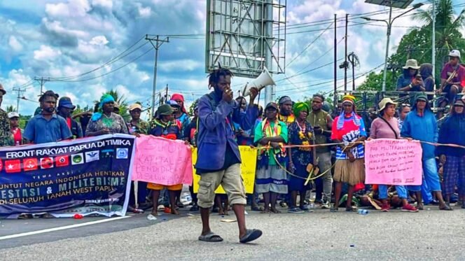 
Aktivis Mahasiswa, Yoki sondegau bersama mama-mama pedagang OAP saat melakukan aksi demonstrasi meminta perlindungan Hak Komoditas Lokal di Timika. (Foto: Istimewa)