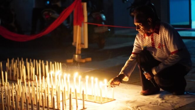 
Seorang Relawan penanganan HIV/Aids sedang menyalakan lilin dalam momen peringatan hari AIDS sedunia, Senin (8/12/2025) di Nabire. (Foto: Kristin Rejang/sasagupapua.com)