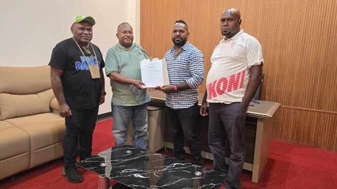 
Ketua KONI Papua Tengah, Yosua Tipagau saat menyerahkan SK menunjukan Karateker KONI Papua Tengah. (Foto: Istimewa) 