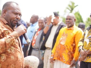 Bupati Intan Jaya, Amer Maisini saat memegang batu sebagai simbol peletakan batu pertama pembangunan gedung Gereja Jemaat GKII Laodikia Jayanti. (Foto: Kristin Rejang/Sasagupapua.com)