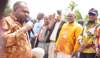 Bupati Intan Jaya, Amer Maisini saat memegang batu sebagai simbol peletakan batu pertama pembangunan gedung Gereja Jemaat GKII Laodikia Jayanti. (Foto: Kristin Rejang/Sasagupapua.com)
