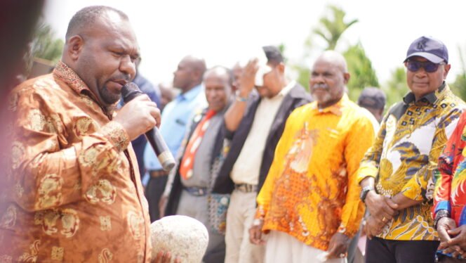 
Bupati Intan Jaya, Amer Maisini saat memegang batu sebagai simbol peletakan batu pertama pembangunan gedung Gereja Jemaat GKII Laodikia Jayanti. (Foto: Kristin Rejang/Sasagupapua.com)
