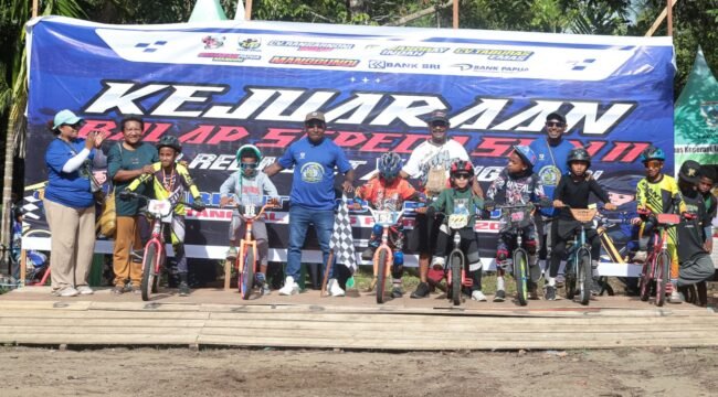 Ketua KNPI Papua Tengah, Yustinus Tebai berfoto bersama para pembalap sepeda dalam acara pembukaan Kegiatan Balap Sepeda Seri II KKB Relingket x Manggundi Papua Tengah, Jumat (13/2/2026). Foto: Yulian Boma for Sasagupapua.com