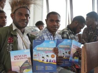 Siswa SMA Negeri Meepago saat menunjukan buku kontekstual karya Yermias Degei yang dipersembahkan oleh Dinas Pendidikan dan Kebudayaan Papua Tengah kepada sekolah. (Foto: Kristin Rejang/Sasagupapua.com)