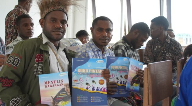 Siswa SMA Negeri Meepago saat menunjukan buku kontekstual karya Yermias Degei yang dipersembahkan oleh Dinas Pendidikan dan Kebudayaan Papua Tengah kepada sekolah. (Foto: Kristin Rejang/Sasagupapua.com) 