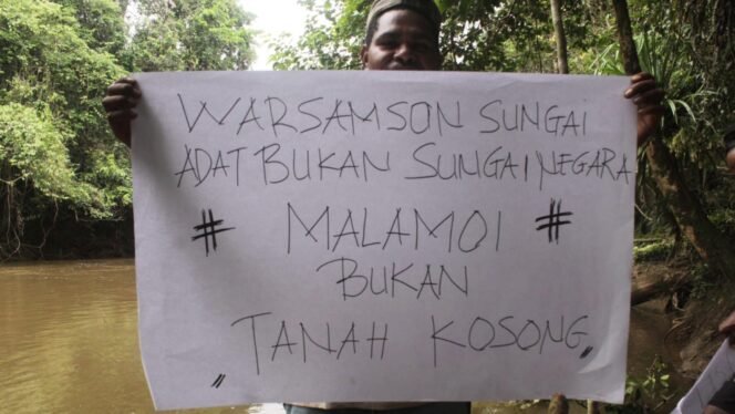 
Seorang pemuda dari Masyarakat Adat Moi saat memegang seruan penolakan pembangunan bendungan Warsamson. (Foto: Istimewa)