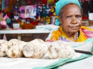 Mama Dominika You sedang berjualan Ubi Bakar di Pasar Karang, Nabire, Papua Tengah. (Foto: Kristin Rejang/Sasagupapua)