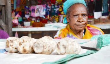 Mama Dominika You sedang berjualan Ubi Bakar di Pasar Karang, Nabire, Papua Tengah. (Foto: Kristin Rejang/Sasagupapua)