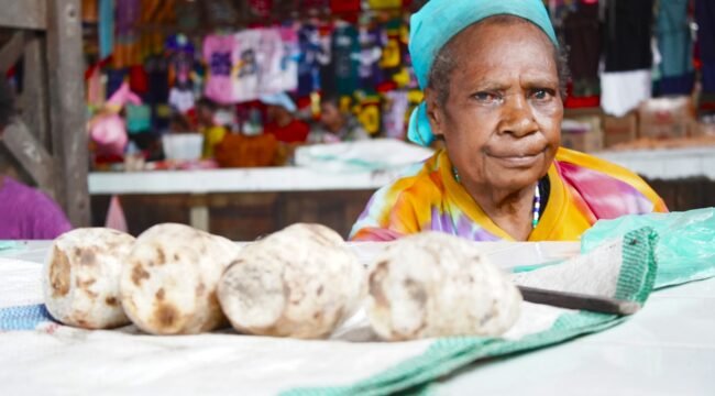 Mama Dominika You sedang berjualan Ubi Bakar di Pasar Karang, Nabire, Papua Tengah. (Foto: Kristin Rejang/Sasagupapua)