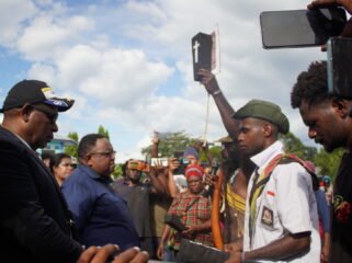Seorang perwakilan masa saat mengangkat sebuah peti kecil sebagai simbol duka di Dogiyai yang diserahkan kepada DPR Papua Tengah, Senin (11/5/2026). Foto: Kristin Rejang/Sasagupapua.com