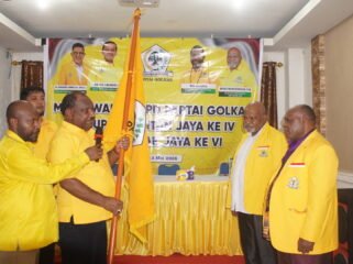 Ketua Harian DPD I Partai Golkar Papua Tengah, Willem Wandik saat menyerahkan bendera pataka kepada ketua terpilih. (Foto: Kristin Rejang/Sasagupapua.com.