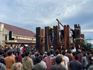 Proses pemasangan tiang utama pembangunan tongkonan di Timika. (Foto: Ist)