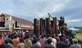 Proses pemasangan tiang utama pembangunan tongkonan di Timika. (Foto: Ist)