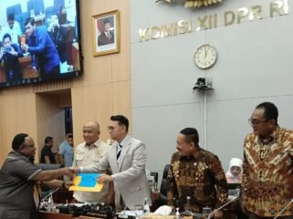 John Gobai saat menyerahkan Laporan Tailing Freeport Komisi XII DPR RI ke Timika. (Foto: Ist)
