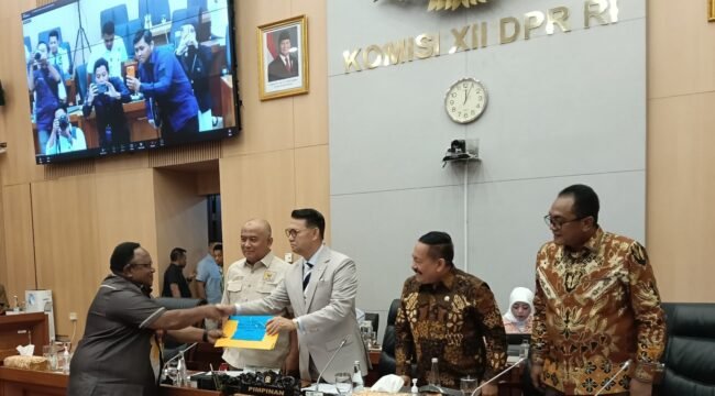 John Gobai saat menyerahkan Laporan Tailing Freeport Komisi XII DPR RI ke Timika. (Foto: Ist)