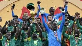 Penyerang Senegal bernomor punggung 10, Sadio Mane, mengangkat trofi saat merayakan kemenangan bersama rekan-rekan setimnya setelah memenangkan pertandingan final Piala Afrika (CAN) 2025 melawan Maroko di Stadion Pangeran Moulay Abdellah di Rabat, Senin (19-1-2026) dini hari WIB. (SEBASTIEN BOZON/AFP)