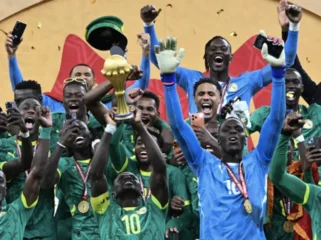 Penyerang Senegal bernomor punggung 10, Sadio Mane, mengangkat trofi saat merayakan kemenangan bersama rekan-rekan setimnya setelah memenangkan pertandingan final Piala Afrika (CAN) 2025 melawan Maroko di Stadion Pangeran Moulay Abdellah di Rabat, Senin (19-1-2026) dini hari WIB. (SEBASTIEN BOZON/AFP)