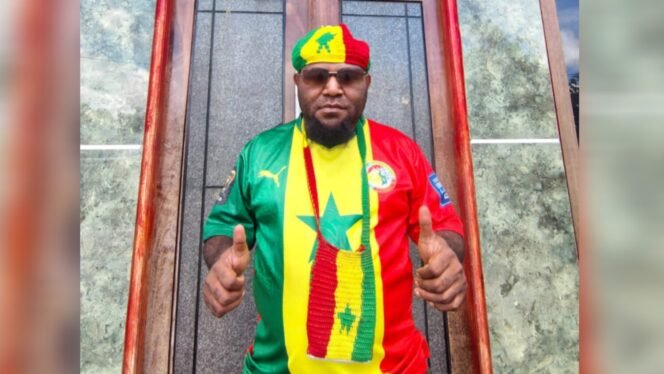 
Ketua Kelompok Khusus DPR Papua Tengah, Donatus Mote saat mengenakan atribut tim kebanggaannya yakni Senegal. (Foto: Dok Pribadi)