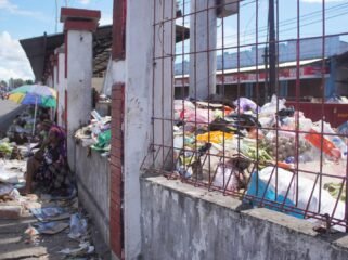 Tampak mama-mama Papua sedang berjualan di pinggir jalan depan Pasar Karang,  namun dibagian belakang tumpukan sampah yang menggunung di dalam area Pasar. (Foto: Kristin Rejang/Sasagupapua.com) 