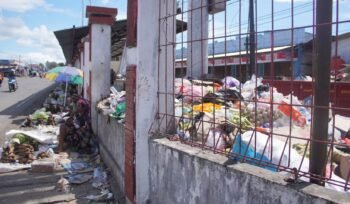 Tampak mama-mama Papua sedang berjualan di pinggir jalan depan Pasar Karang,  namun dibagian belakang tumpukan sampah yang menggunung di dalam area Pasar. (Foto: Kristin Rejang/Sasagupapua.com) 
