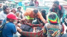 Pastor Dekan Dekenat Moni Puncak Jaya, Yance Yogi, Pr (Baju abu-abu kenakan topi noken) saat ikut mengevakuasi korban ke RSUD Sugapa. (Foto: Ist)