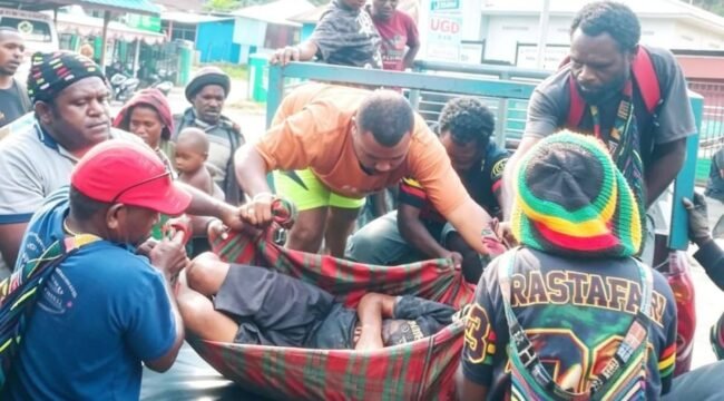 Pastor Dekan Dekenat Moni Puncak Jaya, Yance Yogi, Pr (Baju abu-abu kenakan topi noken) saat ikut mengevakuasi korban ke RSUD Sugapa. (Foto: Ist)