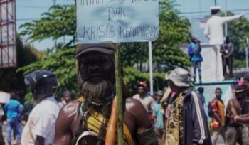 Seorang massa aksi memegang seruan bertuliskan 'Intan Jaya Darurat dan Krisis Kemanusiaan'. (Foto: Kristin Rejang/sasagupapua.com)