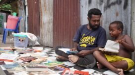 Pegiat Literasi, Mecky Tebai saat berbincang dengan seorang anak saat menggelar lapak baca di komplek Mapiduba. (Foto: Kristin Rejang/Sasagupapua)