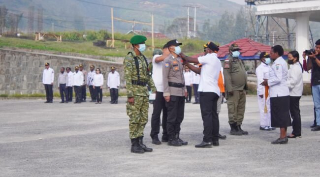 Bupati Paniai, Yanpit Nawipa saat pemberian masker dan penyematan pita secara simbolis dalam Apel Siaga Karhutla di halaman Kantor Bupati. (Foto: Edwin Rumanasen)