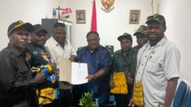 Wakil Ketua IV DPR Papua Tengah, John Gobai saat menyerahkan salinan Perdasi terkait pertambangan rakyat. (Foto: Ist)