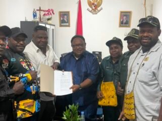 Wakil Ketua IV DPR Papua Tengah, John Gobai saat menyerahkan salinan Perdasi terkait pertambangan rakyat. (Foto: Ist)
