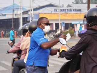 Ketua KNPI Papua Tengah, Yustinus Tebai saat membagikan masker kepada masyarakat. (Foto: Edwin Rumanasen)